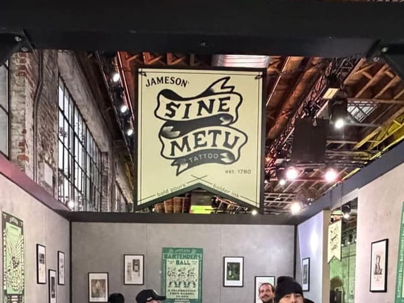 The Sine Metu banner over the tattoo room